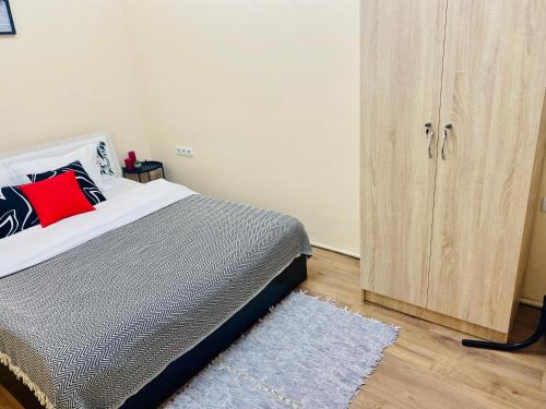- une chambre avec un lit et une armoire en bois dans l'établissement Like Home Rooms, à Almaty
