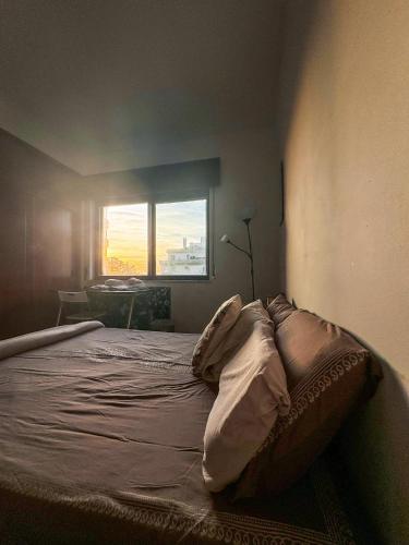 Cette chambre comprend un grand lit et une fenêtre. dans l'établissement Apartamento Chill Stay, à Oeiras