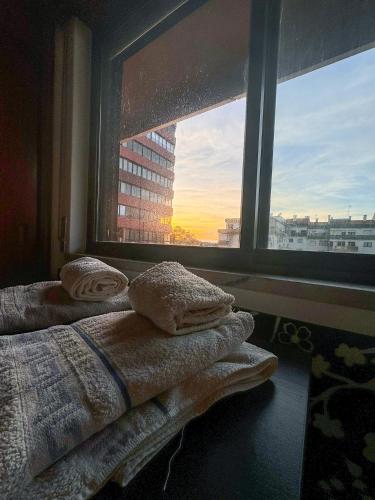 una camera da letto con finestra e asciugamani su un letto di Apartamento Chill Stay a Oeiras
