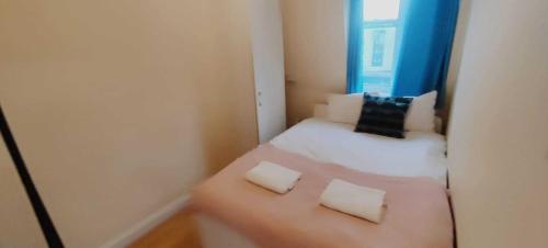 a small room with a bed with two pillows at Kings Central Apartments in Kings Cross in London