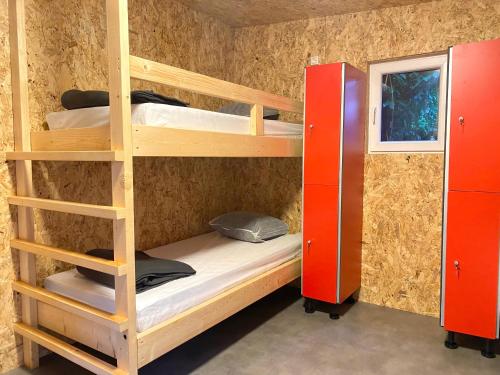 Zimmer mit 2 Etagenbetten und einem Fenster in der Unterkunft Camping la Faloise 