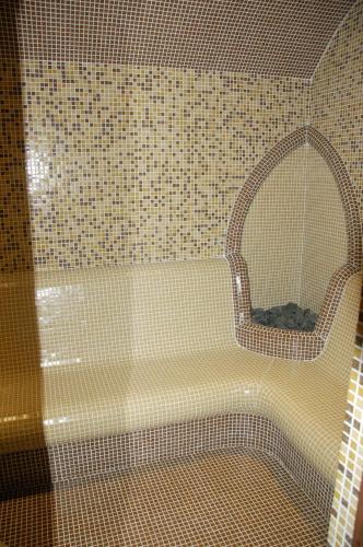 a bathroom with a bath tub with a mirror at Millenium Palace in Ohrid