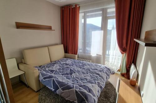 a bedroom with a bed and a window with red curtains at BH & Semiramida Ski Apartment in Borovets