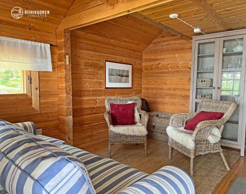 una habitación con 2 sillas y 1 cama en una cabaña en Kalaranta Cottage en Muurame