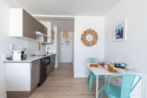 une cuisine avec une table et des chaises bleues dans l'établissement La tranquillité des flots *Wifi * Carnon Plage * Proche Montpellier, à Mauguio