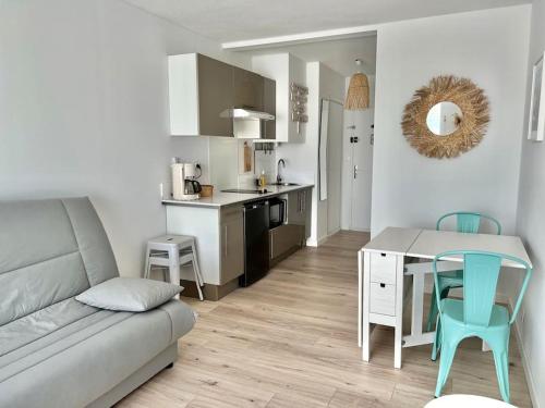 un salon avec un canapé et une table et une cuisine dans l'établissement La tranquillité des flots *Wifi * Carnon Plage * Proche Montpellier, à Mauguio