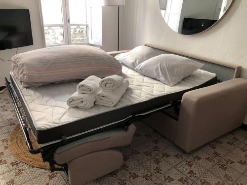 a bed with towels on it with a mirror at ღ Le Cypriano • T2 au Centre de Valence AVEC PARKING in Valence