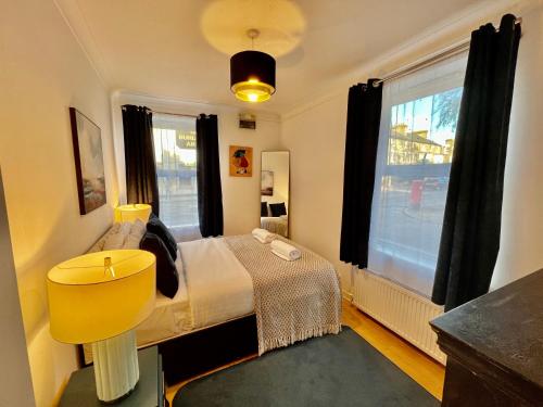 a bedroom with a bed with a yellow chair and a window at Central Cambridge Fig Tree House Flat 1 in Cambridge