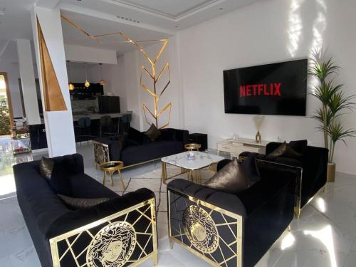 sala de estar con 2 sofás y TV en Villa Valentina, en Marrakech