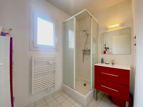 a bathroom with a shower and a red cabinet at Maison récente 6 pers., proche plage, jardin paisible, activités variées - FR-1-639-3 in Saint-Gildas-de-Rhuys