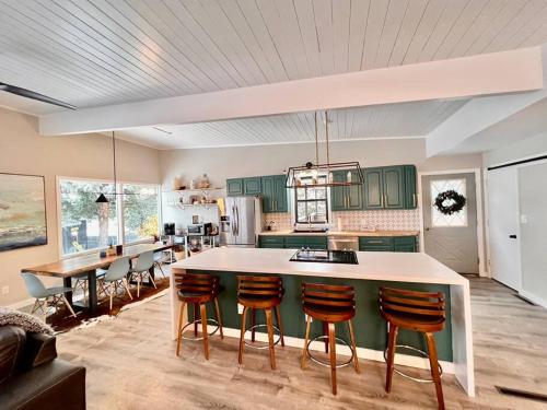 ビュートにあるMid Century Modern Montana Dream Homeのキッチン(緑のキャビネット、白いカウンタートップ付)