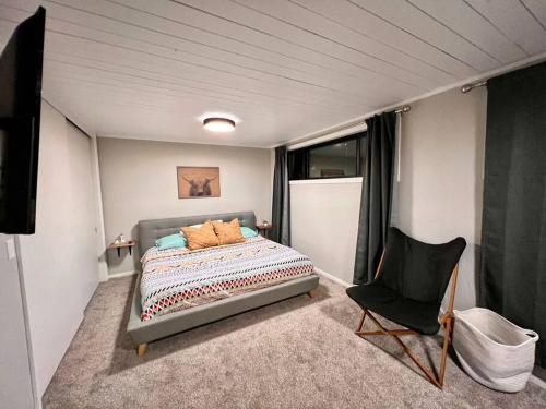 1 dormitorio pequeño con 1 cama y 1 silla en Mid Century Modern Montana Dream Home, en Butte
