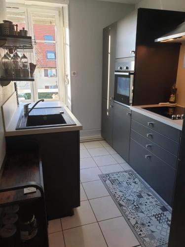 une cuisine avec un évier et une cuisinière dans l'établissement Colmar St Joseph, 2 pièces, à Colmar