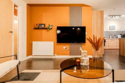 a living room with a table and a tv at Exquisite Living with BicoccaStays in Aberdeen