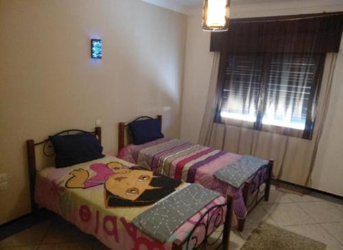 1 dormitorio con 2 camas y ventana en Central Appartement Hamria Meknes, en Meknès