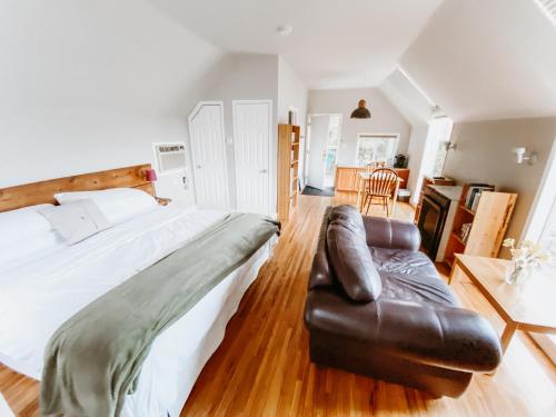 1 dormitorio con 1 cama grande y 1 sofá de cuero en Irish Mountain Suites, en Meaford