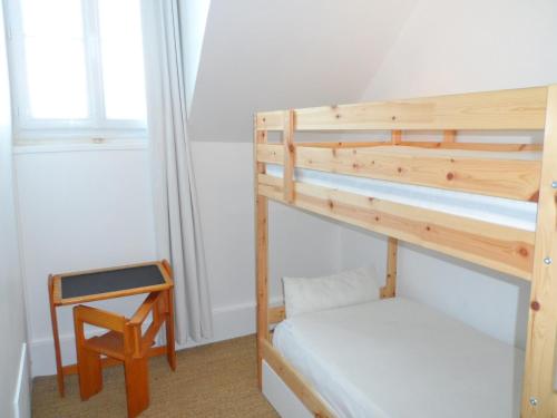 - une chambre avec 2 lits superposés et une chaise dans l'établissement Appartement 3 pièces face à la mer, centre-ville, 54m² pour 5 pers., proche plage, court séjour dispo - FR-1-487-298, à Villers-sur-Mer