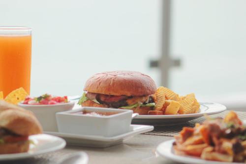 a table with plates of food and a sandwich and fries at Varali Grand Hotel in Mazatlán