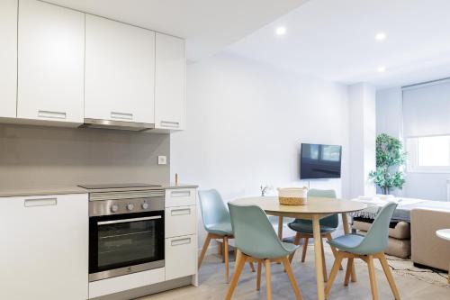a kitchen and dining room with a table and chairs at Apartamentos Nature in Cangas del Narcea