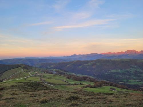 a view of a hill with mountains in the background at Cabaña Pasiega Montes del Pas in La Sota