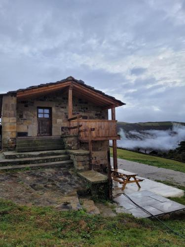 a log cabin with a bench in front of it at Cabaña Pasiega Montes del Pas in La Sota
