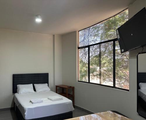 1 dormitorio con cama y ventana grande en Casa Mimaya en Piura