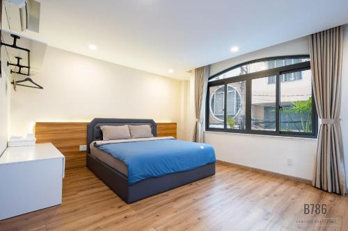 a bedroom with a bed and a large window at B786 Airport Apartment in Ho Chi Minh City