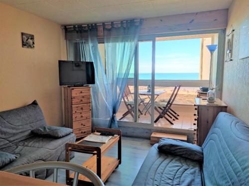 un salon avec un canapé et une télévision et un balcon dans l'établissement Studio idéal plage, balcon, près golf et thalasso - FR-1-652-9, à Saint-Jean-de-Monts