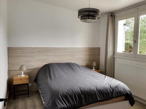 ein Schlafzimmer mit einem großen Bett und einem Fenster in der Unterkunft Maison Saint-Jean-de-Monts, 4 pièces, 6 personnes - FR-1-652-12 in Saint-Jean-de-Monts