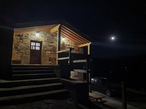 a stone house with stairs and a door at night at Cabaña Pasiega Montes del Pas in La Sota