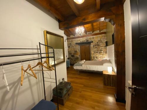 a bedroom with a bed and a stone wall at El Portalón de Luena - Casa Rural in Tablado