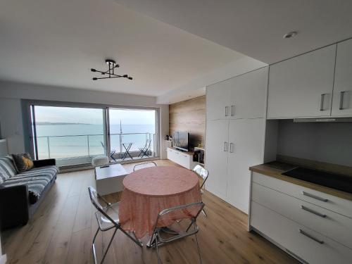 une cuisine avec une table et des chaises dans une pièce dans l'établissement Appartement T2 face plage avec balcon, cuisine équipée et TV - FR-1-92-908, à Les Sables-dʼOlonne
