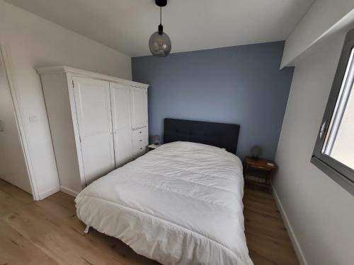 - une chambre avec un lit et une armoire blanche dans l'établissement Appartement T2 face plage avec balcon, cuisine équipée et TV - FR-1-92-908, à Les Sables-dʼOlonne
