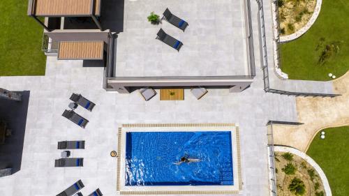 an overhead view of a person swimming in a pool at Imperium Luxury Villas-Sauna, Jacuzzi, Heated Pool & Gym-Chania in Kato Galatas