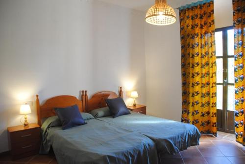 1 dormitorio con 2 camas y ventana en Cortijo San Rafael, en Constantina