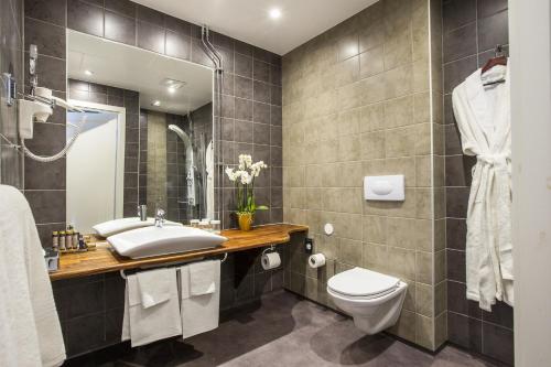 un bagno con lavandino e WC di Sockerslottet Hotell a Kristinehamn