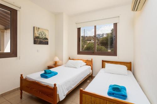 - 2 lits dans une chambre avec fenêtre dans l'établissement Villa Serena, à Pomos