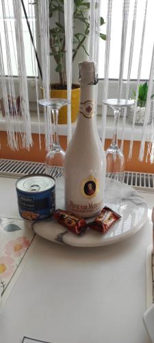 a bottle of first two margarine and a plate with a drink at Apartman B&S Apatin in Apatin