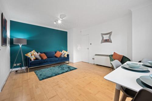 Station Apartment High Wycombe في هاي وايكومب: غرفة معيشة مع أريكة زرقاء وطاولة