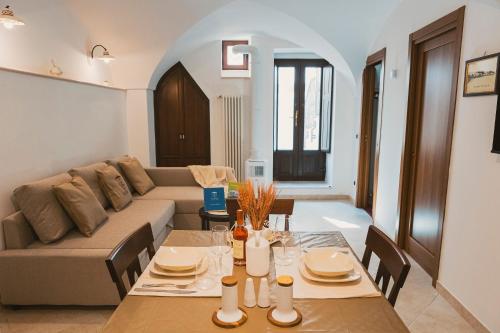 een woonkamer met een bank en een tafel bij Via Dura - Apulian Cozy House in Locorotondo