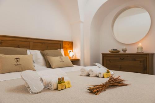 - une chambre avec un lit, des serviettes et un miroir dans l'établissement Via Dura - Apulian Cozy House, à Locorotondo