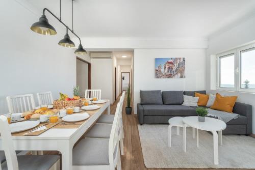 a kitchen and living room with a table and a couch at HostWise - Spacious & Sunny Flat - Loulé in Loulé