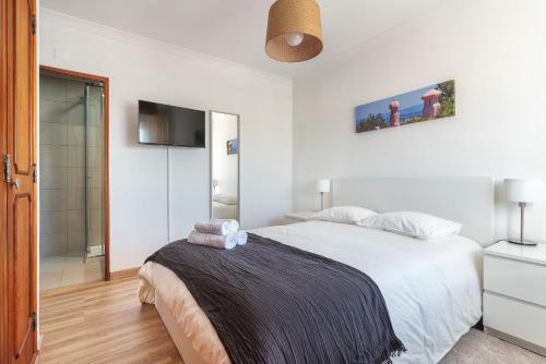 a white bedroom with a bed and a walk in shower at HostWise - Spacious & Sunny Flat - Loulé in Loulé
