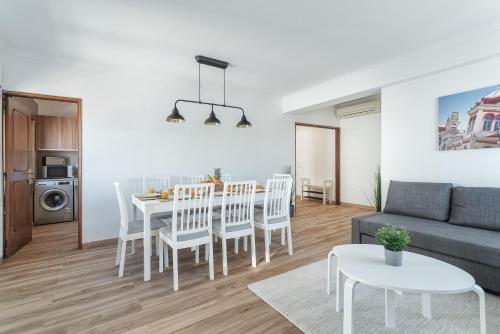 a living room with a table and chairs and a couch at HostWise - Spacious & Sunny Flat - Loulé in Loulé