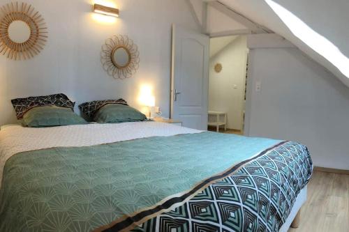 sypialnia z łóżkiem i lustrem na ścianie w obiekcie 15 personnes Chez Delphine et Guillaume w mieście Montbard