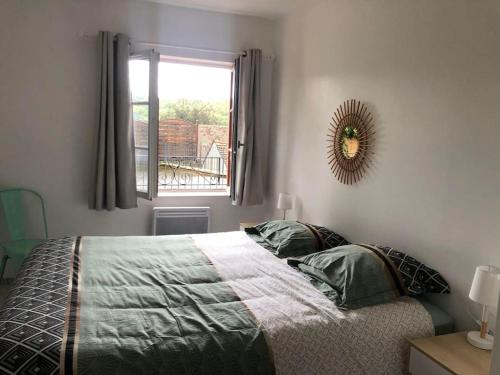 a bedroom with a bed with a mirror and a window at 15 personnes Chez Delphine et Guillaume in Montbard