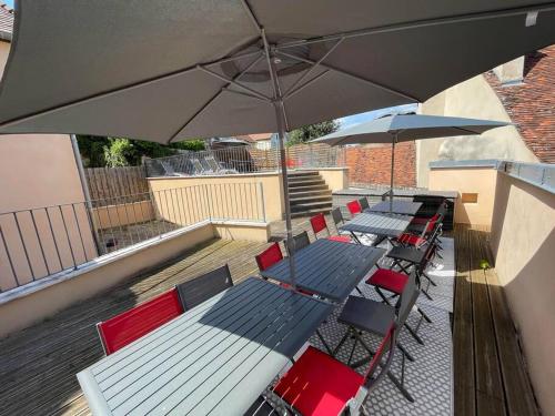 a row of chairs and tables with umbrellas on a patio at 15 personnes Chez Delphine et Guillaume in Montbard