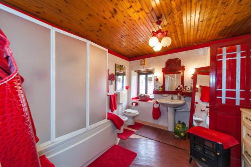 uma casa de banho com uma casa de banho em vermelho e branco com um WC e um lavatório. em La baia dei lupi em Rezzano