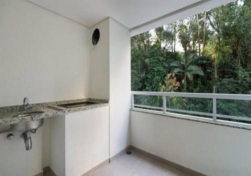 a kitchen with a sink and a large window at Quality Place Apartments by BnbHost in São Paulo