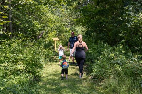 a family walking down a path in the woods at Seascape Motel & Cottages in Belfast